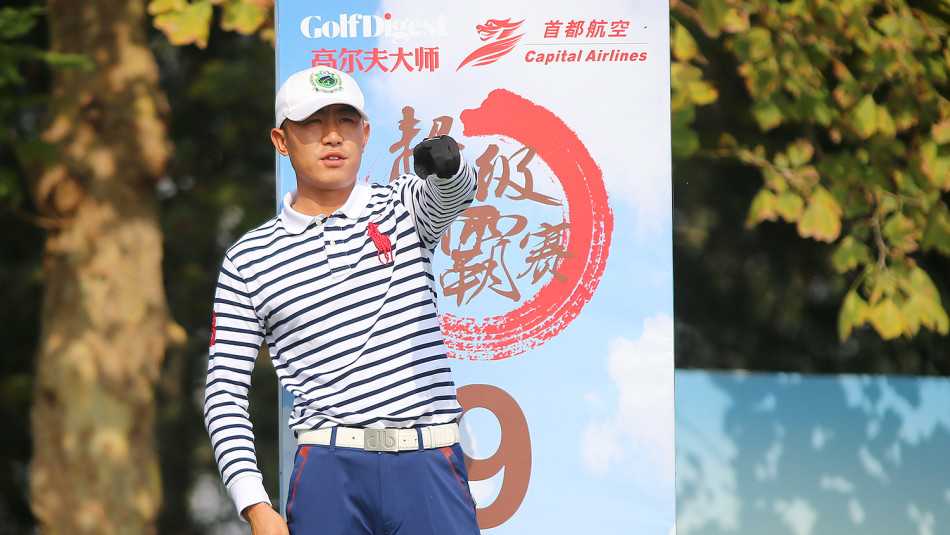 高尔夫球手姚学锋正全神贯注地观察果岭地形，他目光深邃，正在脑中描绘小白球滚向球洞的完美弧线。