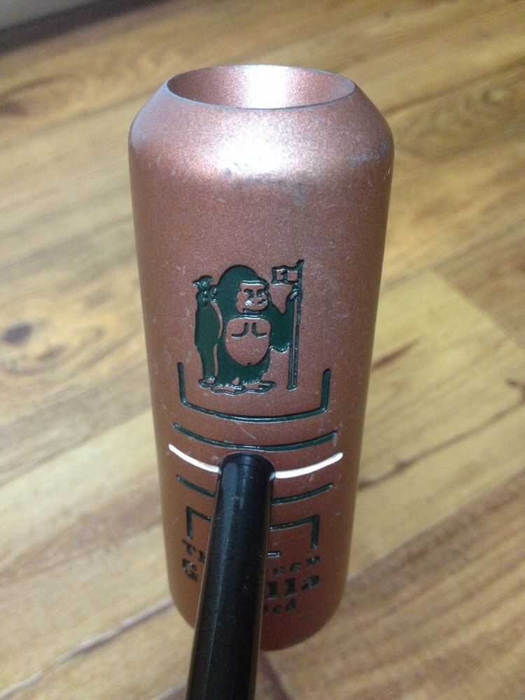 推杆俯瞰视角：金色圆柱杆头与笔直的黑色杆身形成鲜明对比，顶部的瞄准凹陷如同一个精确的导航标记，静静地指向果岭远方。