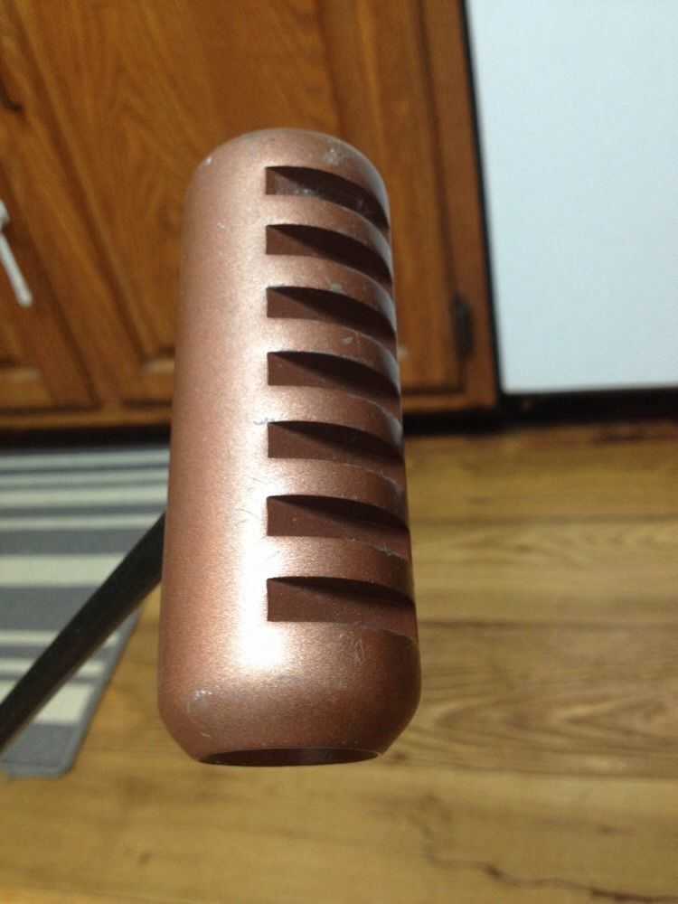 金色圆柱形推杆杆头特写：顶部优雅凹陷，在果岭阳光照射下闪烁着温暖的金属光泽，底部独特的并排镂空结构清晰可见，尽显九十年代的经典工艺。