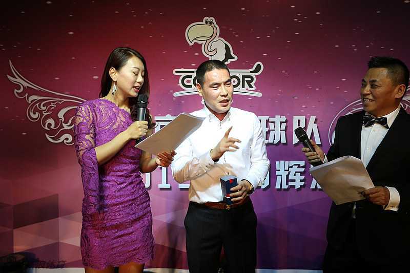 一位代表在台上热情发言，背后屏幕展示着团队一年的精彩历程与辉煌数据