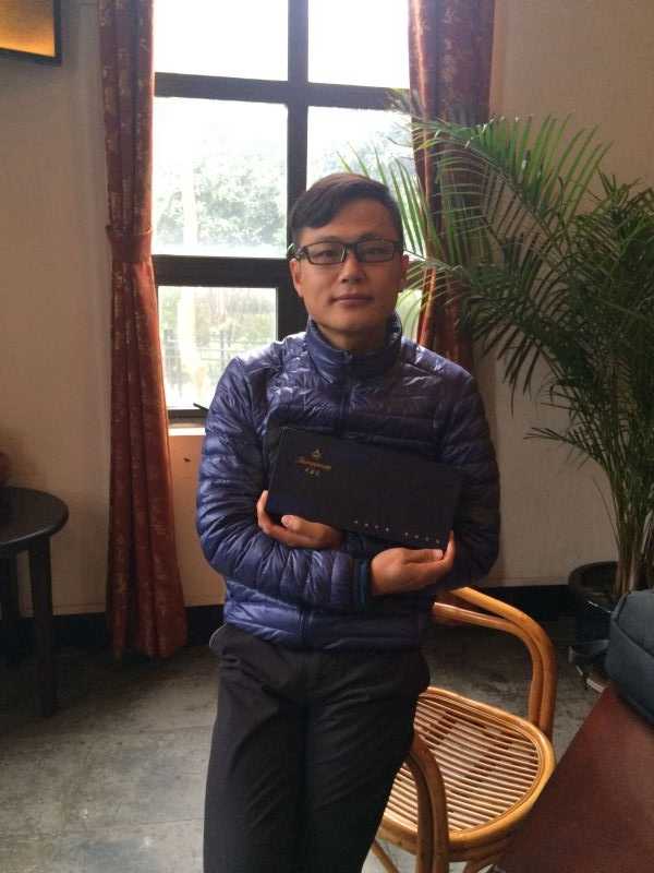 礼仪小姐手持打开的芙蓉王百鸟争鸣礼盒，盒内精美排列的产品在灯光下熠熠生辉